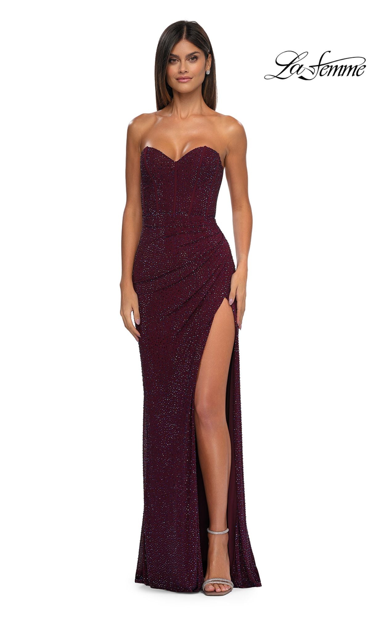 A woman models the La Femme 32422 Strapless Long Glitter Prom Dress in burgundy, featuring a sweetheart neckline and high slit, against a white background with the